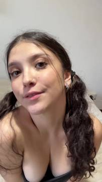 Brunette beauty with pigtails teases her tits in a black top